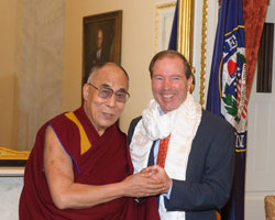 Tom Udall standing with the Dalai Lama shaking hands